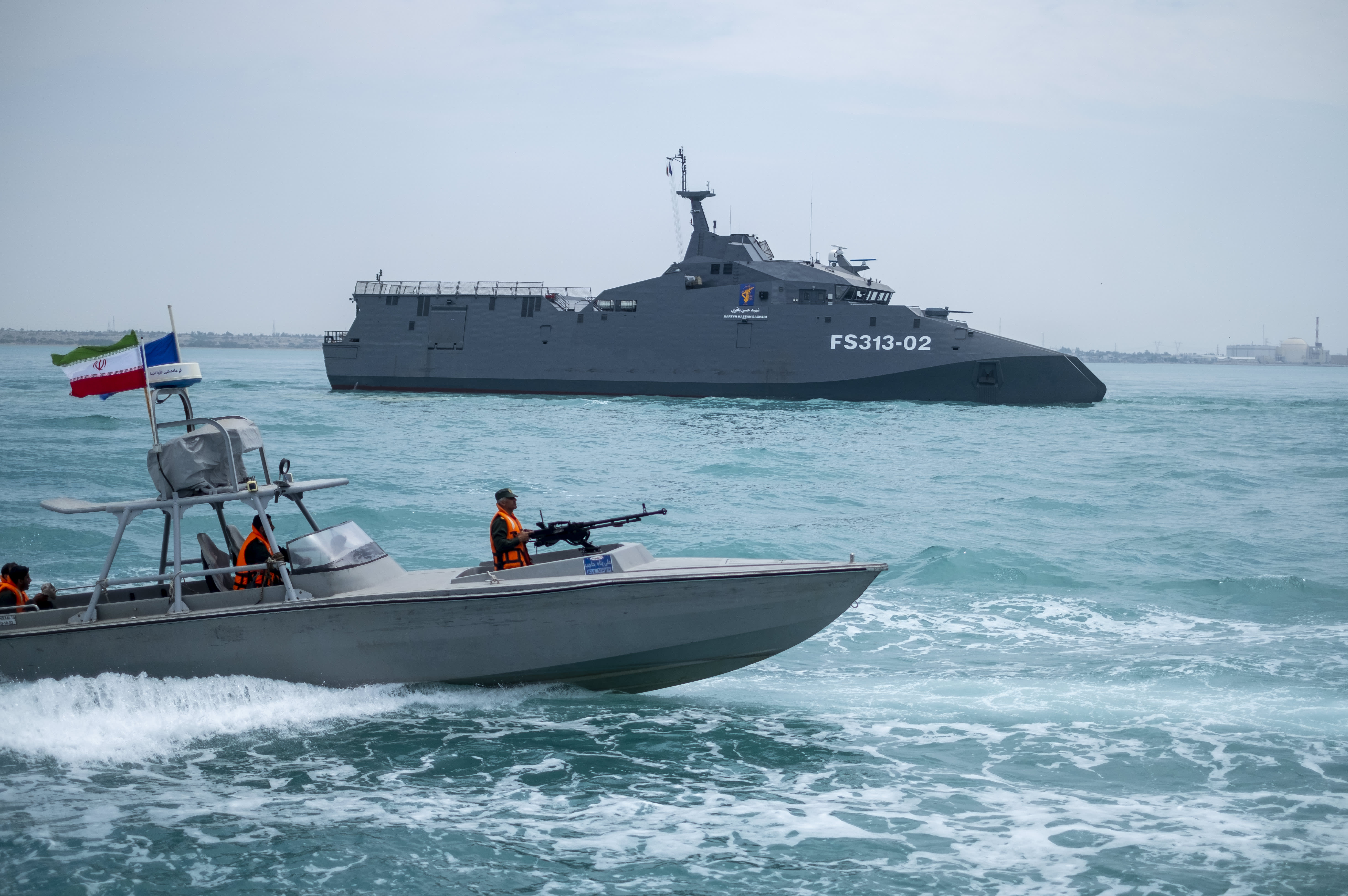 The IRGC Navy Martyr Hassan Bagheri warship and an IRGC speed boat are sailing along the Persian Gulf during the IRGC marine parade, which is commemorating the Persian Gulf National Day, near the Bushehr nuclear power plant in the seaport city of Bushehr, Bushehr province, in the south of Iran, on April 29, 2024. 